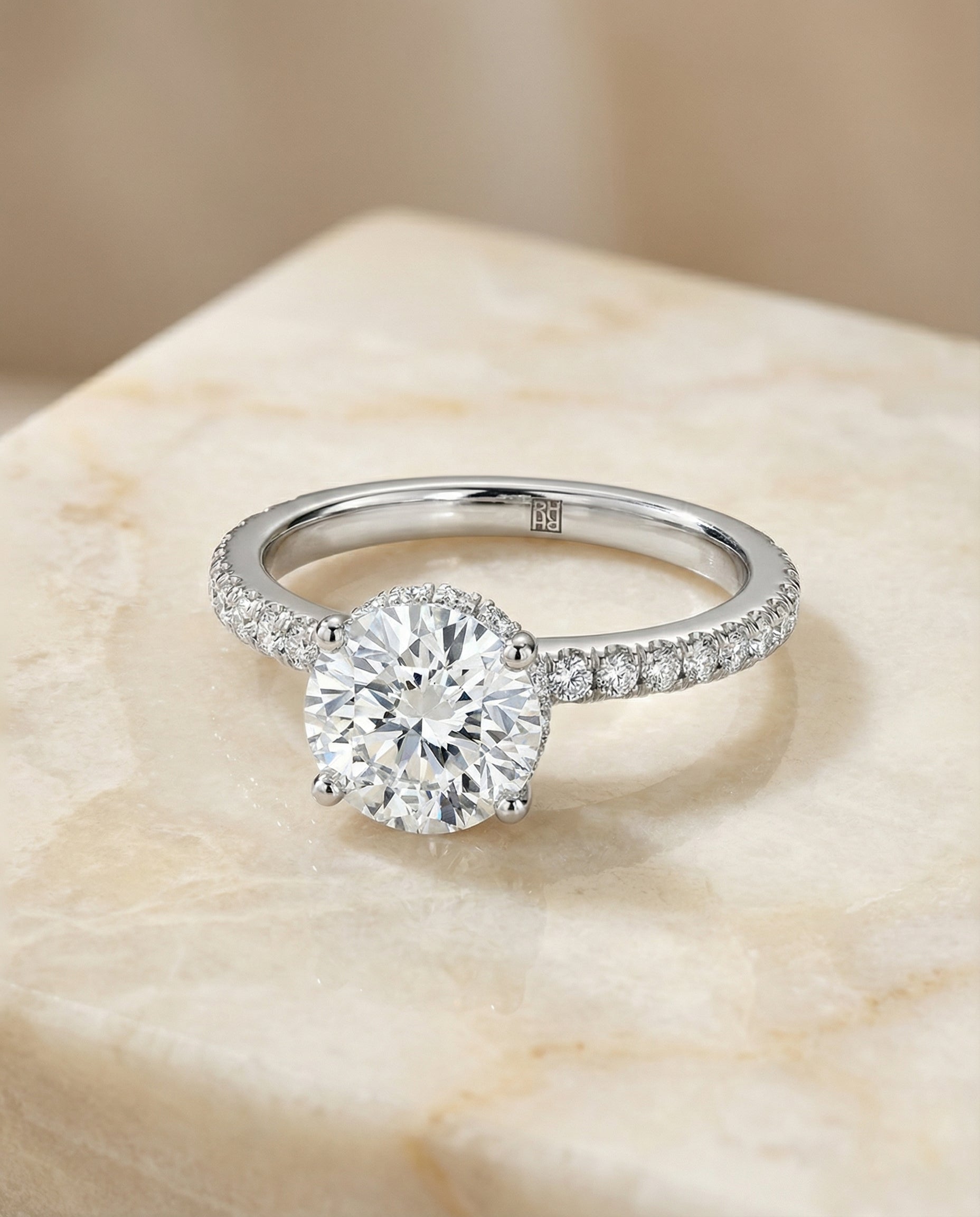 Round Brilliant, Secret Halo French Pavé Solitaire, in Platinum – angled view | RockHer