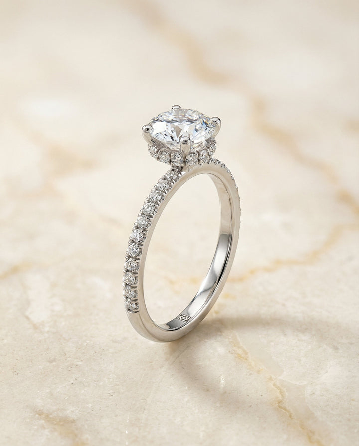 Round Brilliant, Secret Halo French Pavé Solitaire, in Platinum – front view | RockHer