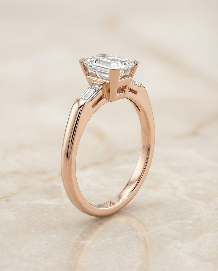 European Cut, Tapered Baguette Three Stone Emerald, in 14K Rose Gold, prong setting – side profile | RockHer