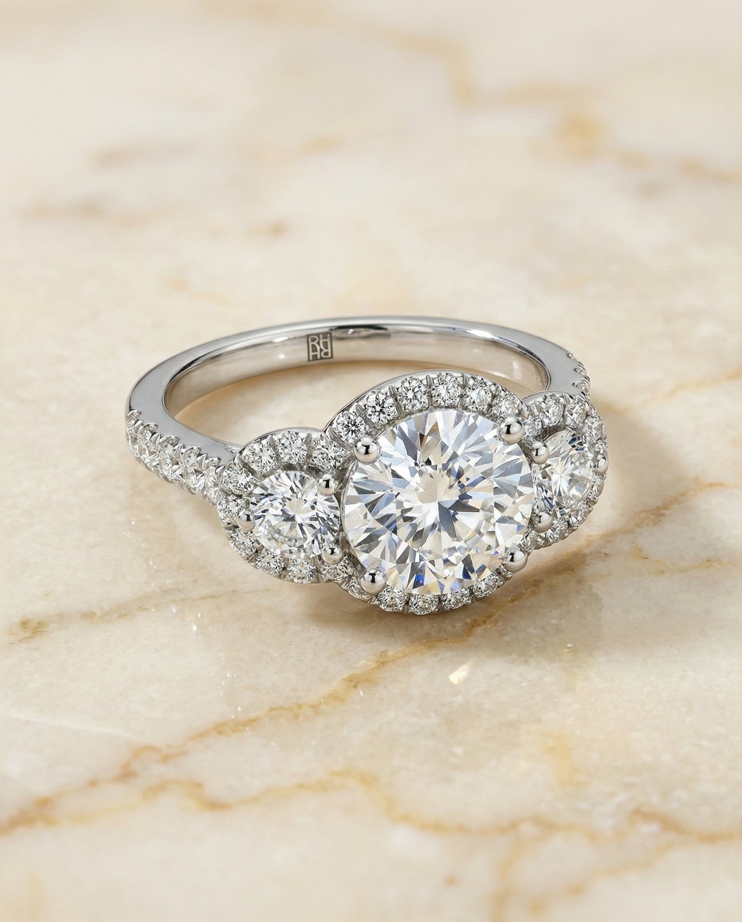 Round Brilliant, Three Stone Halo, in Platinum, pave setting – angled view | RockHer