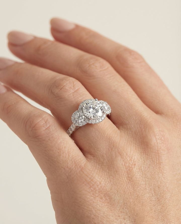 Round Brilliant, Three Stone Halo, in Platinum, pave setting – lifestyle shot | RockHer