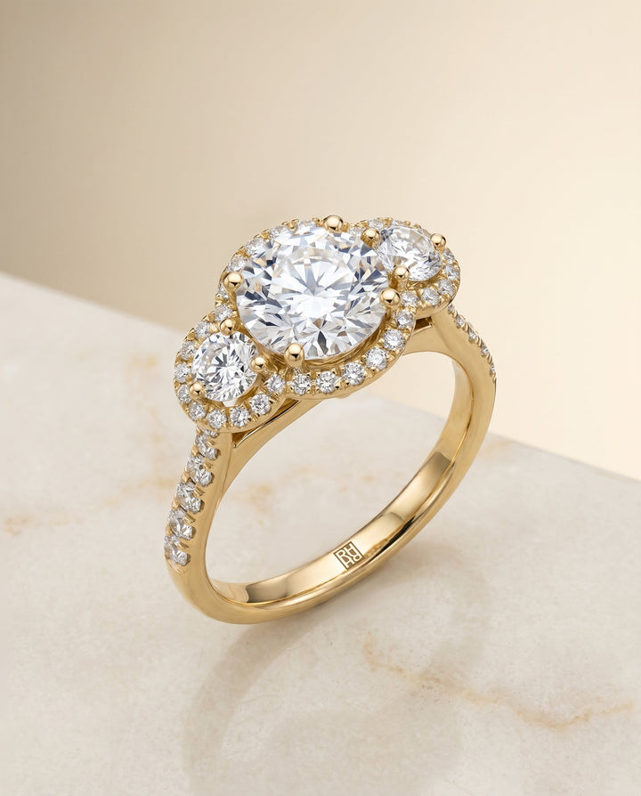 Round Brilliant, Three Stone Halo, in 18K Yellow Gold, pave setting – angled view | RockHer